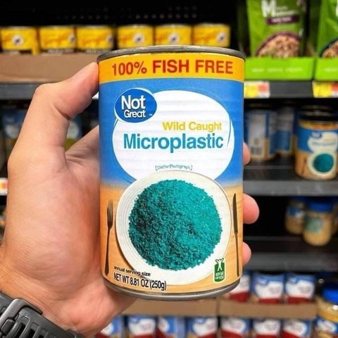 Shot of a hand holding a tin can in front of store shelves. The label reads "Wild Caught Microplastic" "100% FISH FREE" 